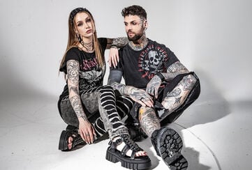Original Sinners / Hier geht&rsquo;s nicht um brave Looks. Die Original Sinners Kollektion steht f&uuml;r rock- und bikerinspirierte Streetwear: roh, rebellisch und authentisch. Dunkle, verwaschene Farbwelten, Used-Optiken und Tattoo-&Auml;sthetik formen eine klare Designsprache. Totenk&ouml;pfe, Fl&uuml;gel, Kreuze und Heraldik treffen auf vintage-inspirierte Typografie &ndash; jedes Teil wirkt wie ein Statement-Piece mit starkem Wiedererkennungswert.Aufwendig umgesetzte Prints &ndash; von Front bis Allover &ndash; verschmelzen mit Stickereien, Patches und strukturierten Oberfl&auml;chen. Schn&uuml;rungen, B&auml;nder, Raw Edges sowie Destroyed-Details geben Tiefe und Haltung; Batik- und Acid-Wash-Effekte sorgen f&uuml;r charaktervolle Patina. Die Silhouetten sind bew&auml;hrt und pr&auml;zise geschnitten: figurnahe T-Shirts und Longsleeves, Layering-Pieces wie Hoodies, Zip-Jacken und Westen. F&uuml;r Frauen tailliert mit subtilen, femininen Akzenten; f&uuml;r M&auml;nner maskulin und k&ouml;rperbetont. Classic-Fits, modern veredelt.Original Sinners ist Rockwear mit Charakter &ndash; kompromisslos im Stil, hochwertig in der Umsetzung und fernab kurzlebiger Trends. F&uuml;r alle, die ihren Look nicht erkl&auml;ren m&uuml;ssen, sondern tragen. Zeitlose Rock-Styles, modern interpretiert und gemacht f&uuml;r die Stra&szlig;e. Original Sinners &ndash; gemacht f&uuml;r Unangepasste. / Jetzt entdecken!